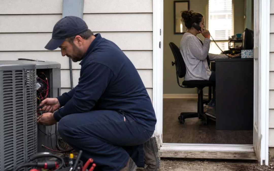 Home service technician working while an office receptionist handles a call